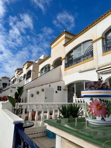 a building with a balcony with flowers on a table at Sonido del Mar in Gran Alacant
