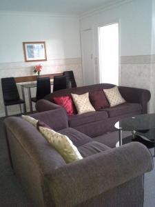 a living room with two couches and a table at Hobart Apartments in Hobart