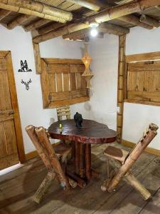 une table et des chaises en bois dans une chambre avec une table dans l'établissement Cabaña Bamboo House, à Calarcá