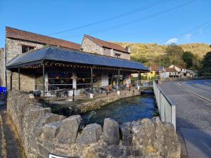 a restaurant on a river next to a road at Purdie Close Holiday Let in Cheddar