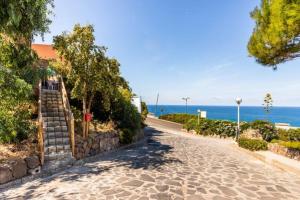 una calle adoquinada con una escalera junto al océano en MAREVIGLIOSO MAREVELLOUS Fronte Mare Sea Front, en Magomadas