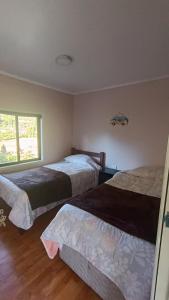 sypialnia z 2 łóżkami i oknem w obiekcie Cabañas vista playa San Ignacio w mieście Valdivia