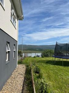 a house with a tent on the side of a field at Lakeside Apartments in Egilsstaðir