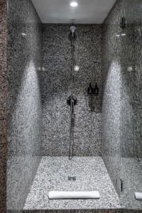 a shower in a bathroom with a shower at The Atrium Hotel & Conference Centre Paris CDG Airport, by Penta in Roissy-en-France