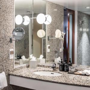 a bathroom with a sink and a large mirror at The Atrium Hotel & Conference Centre Paris CDG Airport, by Penta in Roissy-en-France