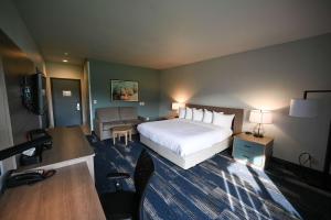 a hotel room with a bed and a living room at Edgewater Inn and Suites in Coos Bay