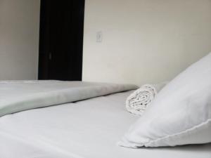 a white bed with white sheets and pillows at Apartahotel Barú - Usaquén in Bogotá