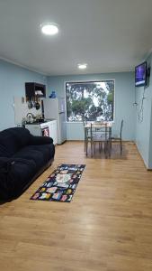 salon z czarną kanapą i stołem w obiekcie Cabañas vista playa San Ignacio w mieście Valdivia