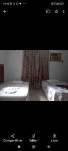 a picture of a room with two beds and avertisement at Recanto Renascer (hostel e Pousada) in Rio Branco