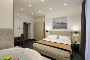 Best Western Hotel dei Mille في نابولي: غرفة في الفندق مع سرير وحوض استحمام