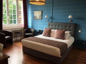 a bedroom with a large bed with blue walls at La Bonbonniere - Sure Hotel Collection by Best Western in Talant
