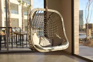 a wicker hanging chair with pillows on a patio at Dakhla South Bay in Dakhla