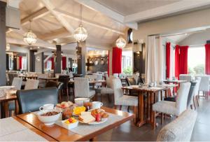 un ristorante con tavoli e sedie con cibo sopra di Best Western Hotel Acadie Paris Nord Villepinte a Tremblay-en-France