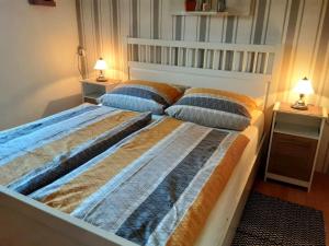 two beds in a bedroom with two lamps on tables at -Heaf half between North and Ostsee U Schlei in Ellingstedt