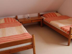 twee bedden in een kamer met twee tafels bij Holiday apartment in Norddeich