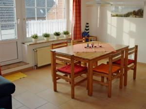 een keuken met een houten tafel met vier stoelen bij Holiday apartment in Norddeich