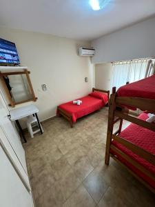 una stanza con due letti e una scrivania di Verona Hostel a Necochea