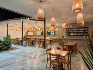 een restaurant met houten tafels, stoelen en verlichting bij Finca del Café - Casa Bourbon in Santa Rosa de Cabal