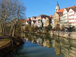 a river in a city with houses and buildings at Epple in Tübingen am Neckar in Tübingen