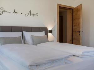 - un grand lit blanc avec les mots d'un ange sur le mur dans l'établissement Green Residence L II, à Wildschönau