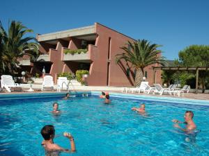 a group of people swimming in a swimming pool at Residence Maricampo in Marina di Campo