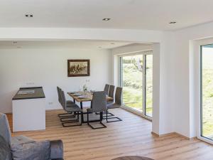 - une cuisine et une salle à manger avec une table et des chaises dans l'établissement Green Residence LM II, à Wildschönau