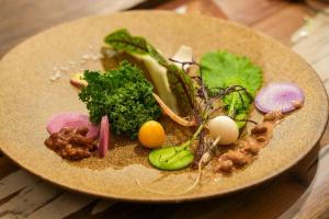 un plato de comida con verduras en una mesa en Kamaitai Inn ONE and ONLY - Vacation STAY 65431v, en Biei