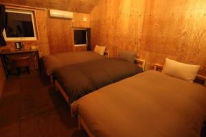 1 Schlafzimmer mit 2 Betten, einem Schreibtisch und einem Fenster in der Unterkunft Kamaitai Inn ONE and ONLY - Vacation STAY 65431v in Biei