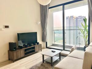 a living room with a television and a large window at DU’s Happy Vinhomes Quận 9 in Long Bình