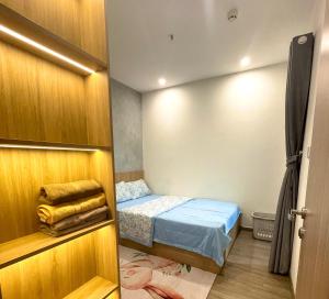 um pequeno quarto com uma cama e um armário em DU’s Happy Vinhomes Quận 9 em Long Bình