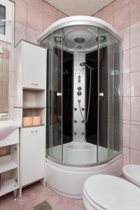 a bathroom with a shower with a toilet and a sink at Apartments by the sea Seget Vranjica, Trogir - 5964 in Seget Vranjica