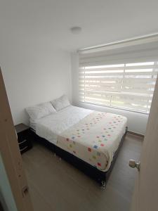 a bedroom with a bed in front of a window at Apartamento - Cardio Infantil CTIC in Bogotá