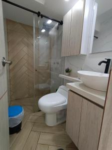 y baño con aseo, lavabo y ducha. en Apartamento - Cardio Infantil CTIC, en Bogotá