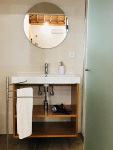 y baño con lavabo y espejo. en AMU- Apartamentos Mistérios da Urzelina, en Urzelina