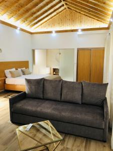 ein Wohnzimmer mit einem Sofa und einem Bett in der Unterkunft AMU- Apartamentos Mistérios da Urzelina in Urzelina