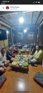 枚州的住宿－Mai Chau Home Holiday，一群人坐在桌子旁吃着食物