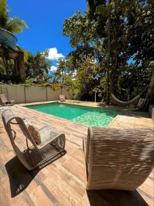 a chair sitting on a deck next to a swimming pool at Pousada Fruta Pão in Barra Grande