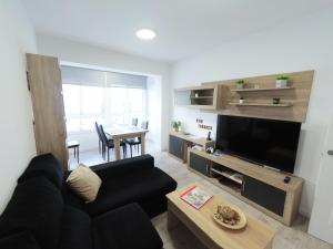 a living room with a black couch and a table at Apartamento New Tarraco in Tarragona