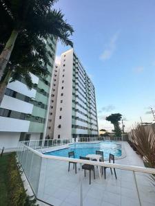 un edificio con piscina di fronte a un edificio di Apto 6 min da praia da Pajuçara a Maceió