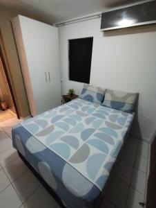 una camera con letto e piumone blu di Apto 6 min da praia da Pajuçara a Maceió