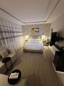 a bedroom with a bed and a couch and a tv at استديو فاخر بمنطقة مركزية in Riyadh