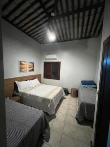 um quarto com duas camas e uma televisão em Casa em Guarajuba em Camassari