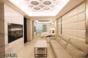 sala de estar con sofá y TV en Chimei Fashion Hotel en Zhongli