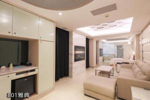 ein Wohnzimmer mit einem Sofa und einem TV in der Unterkunft Chimei Fashion Hotel in Zhongli