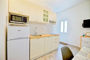 a kitchen with a white refrigerator and a microwave at Apartments with a parking space Postira, Brac - 22150 in Postira