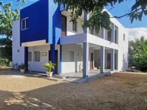 una casa azul y blanca con patio en DaDaJuBa Aparta hotel, en Santa Bárbara de Samaná