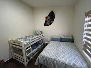 1 dormitorio con 1 cama y 1 litera en Casa de playa en Baja Malibú, Rosarito en San Antonio del Mar