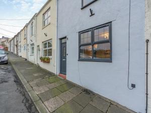 a white building with a window and a street at Appletree Cottage in Cornsay