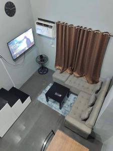 uma sala de estar com um sofá e uma televisão em CV Industrial Place em Antipolo