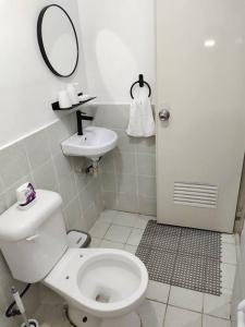 uma casa de banho com um WC, um lavatório e um espelho. em CV Industrial Place em Antipolo